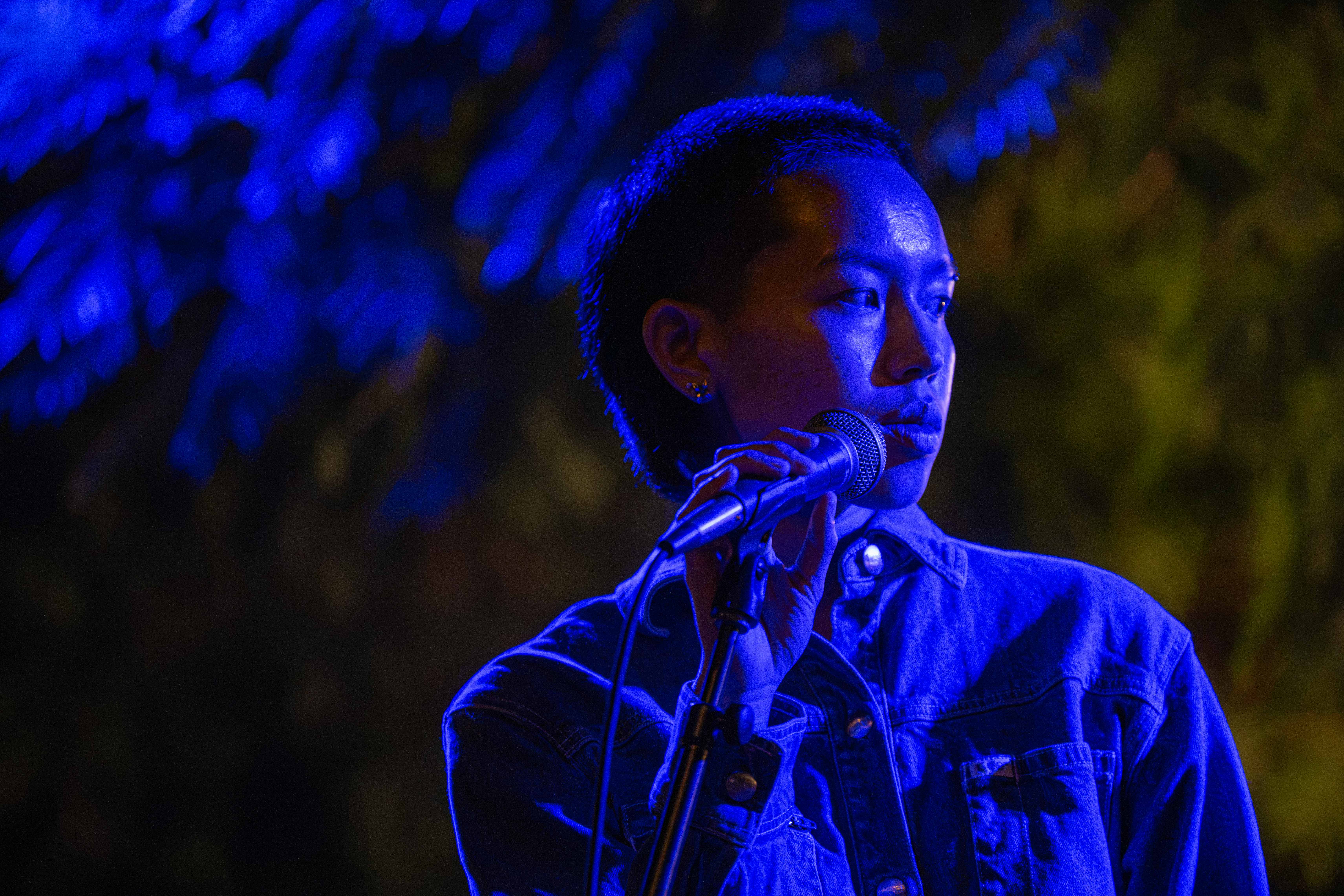 Konani looks to the side while holding the microphone. The concert was located at the Royce Terrace. (Presley Liu/Daily Bruin senior staff)