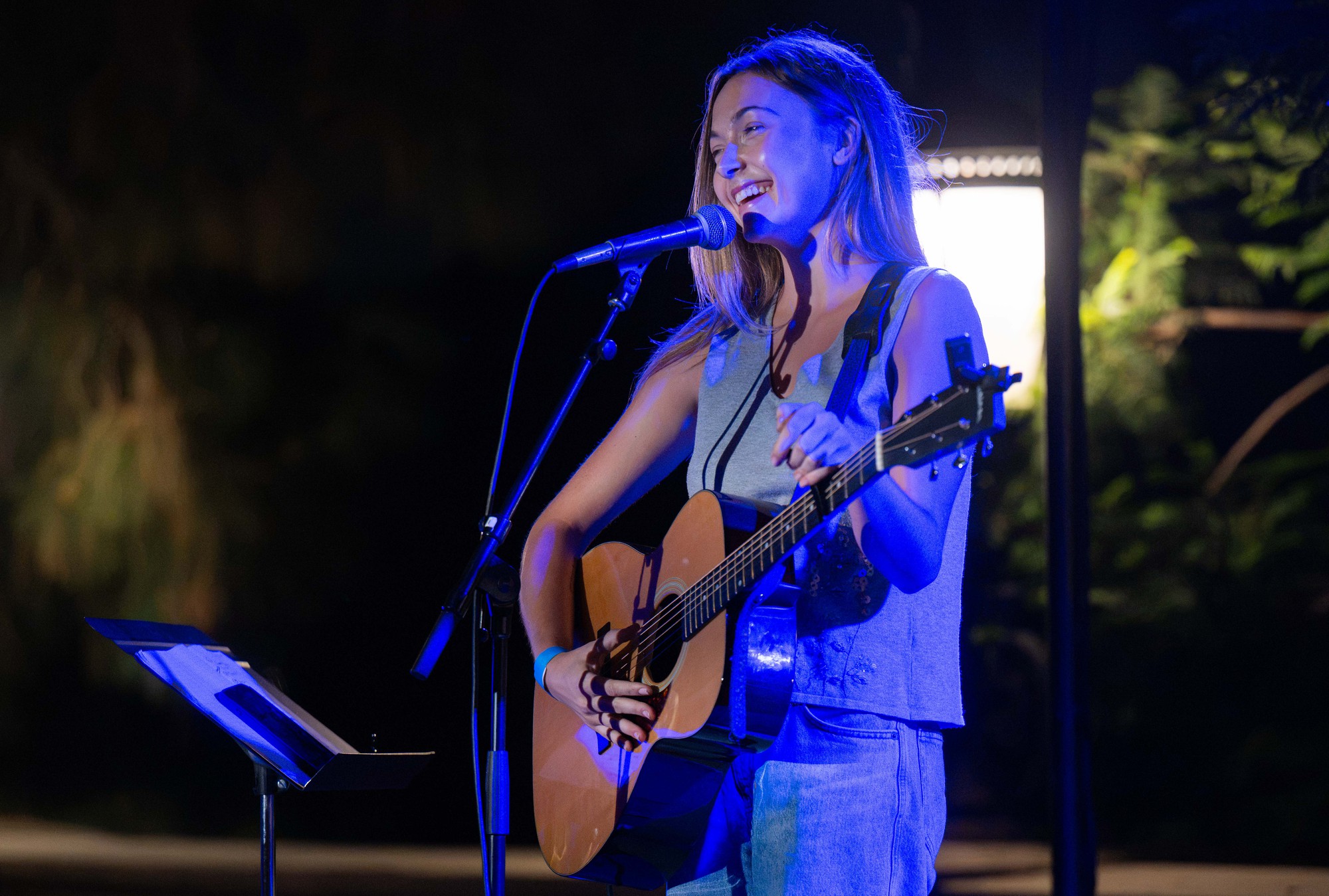 Ryann Barnes smiles while playing a guitar. The fourth-year music industry student closed out the night with her original song “Daisy Chain." (Presley Liu/Daily Bruin senior staff)