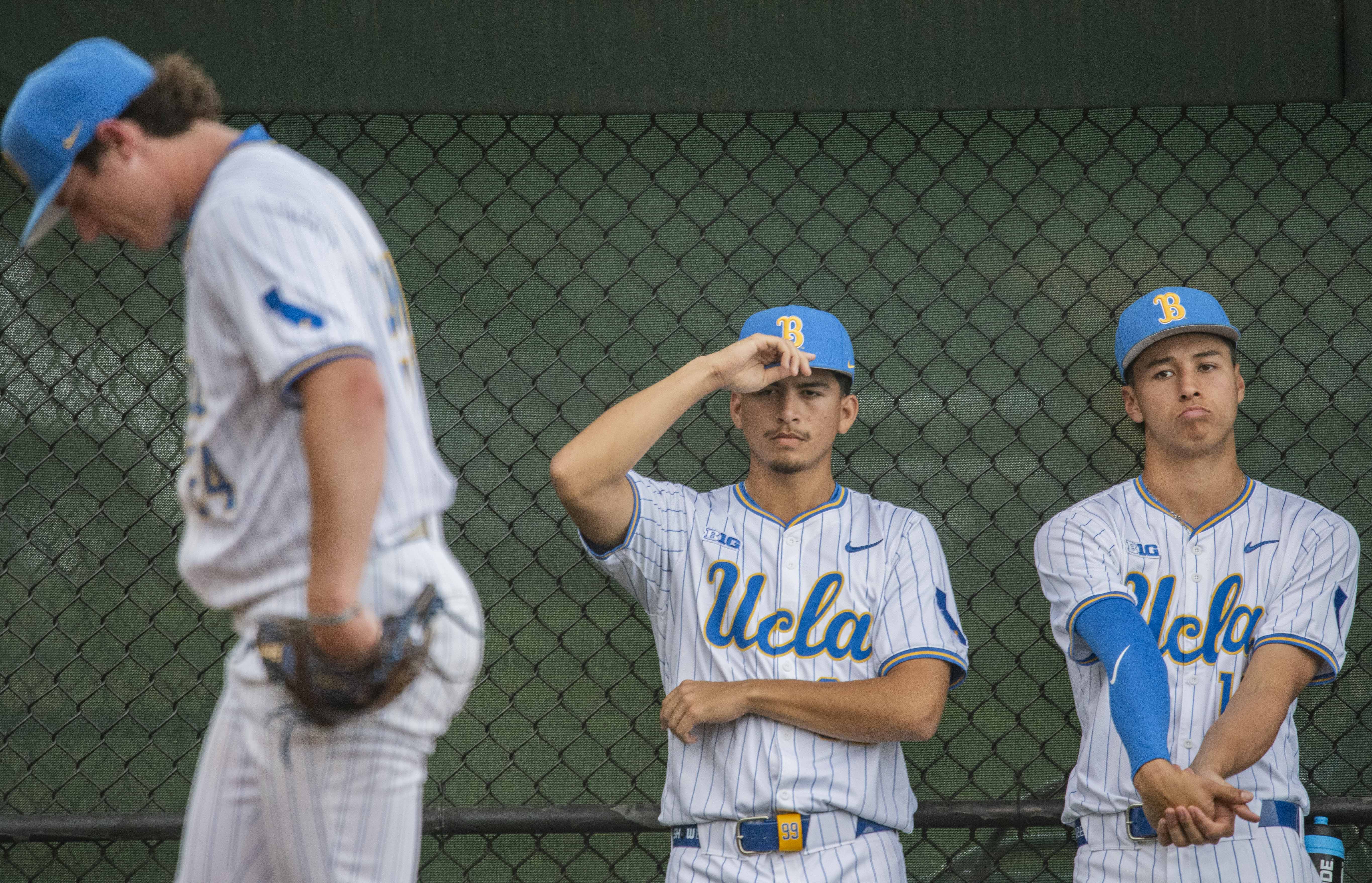 Sophomore right-hander Angel Cervantes (center) and junior right-hander Wylan Moss (right) watch 2026 MLB Draft second-round pick Logan Reddemann warm up in the Bruin bullpen. (Kai Dizon/Assistant Photo editor)