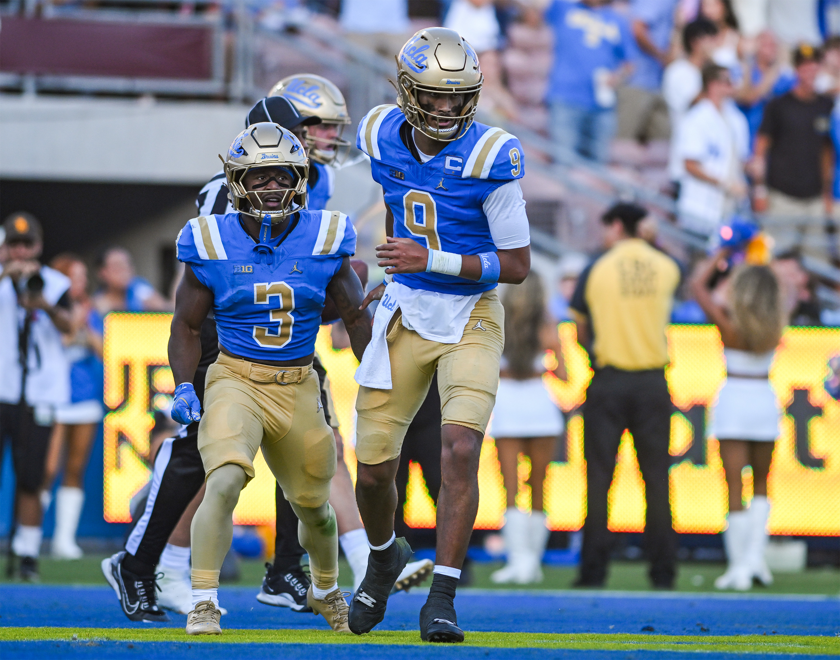 Redshirt junior quarterback Nico Iamaleava runs back to the sideline after greeting fifth-year running back Wayne Knight following the latter’s rushing touchdown. (Presley Liu/Daily Bruin senior staff)
