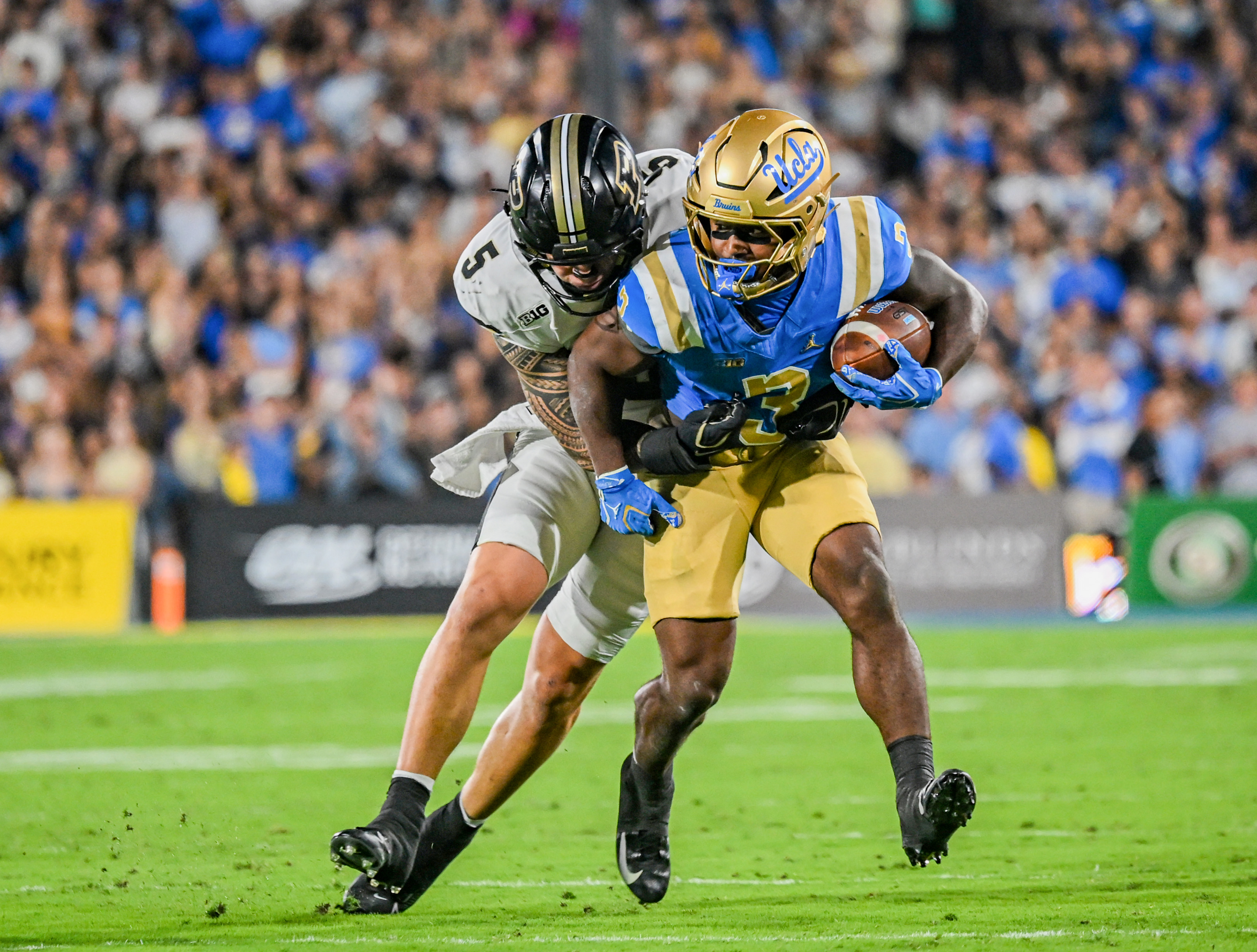 Fifth-year running back Wayne Knight drags Purdue linebacker Charles Correa across the gridiron. (Kai Dizon/Assistant Photo editor)