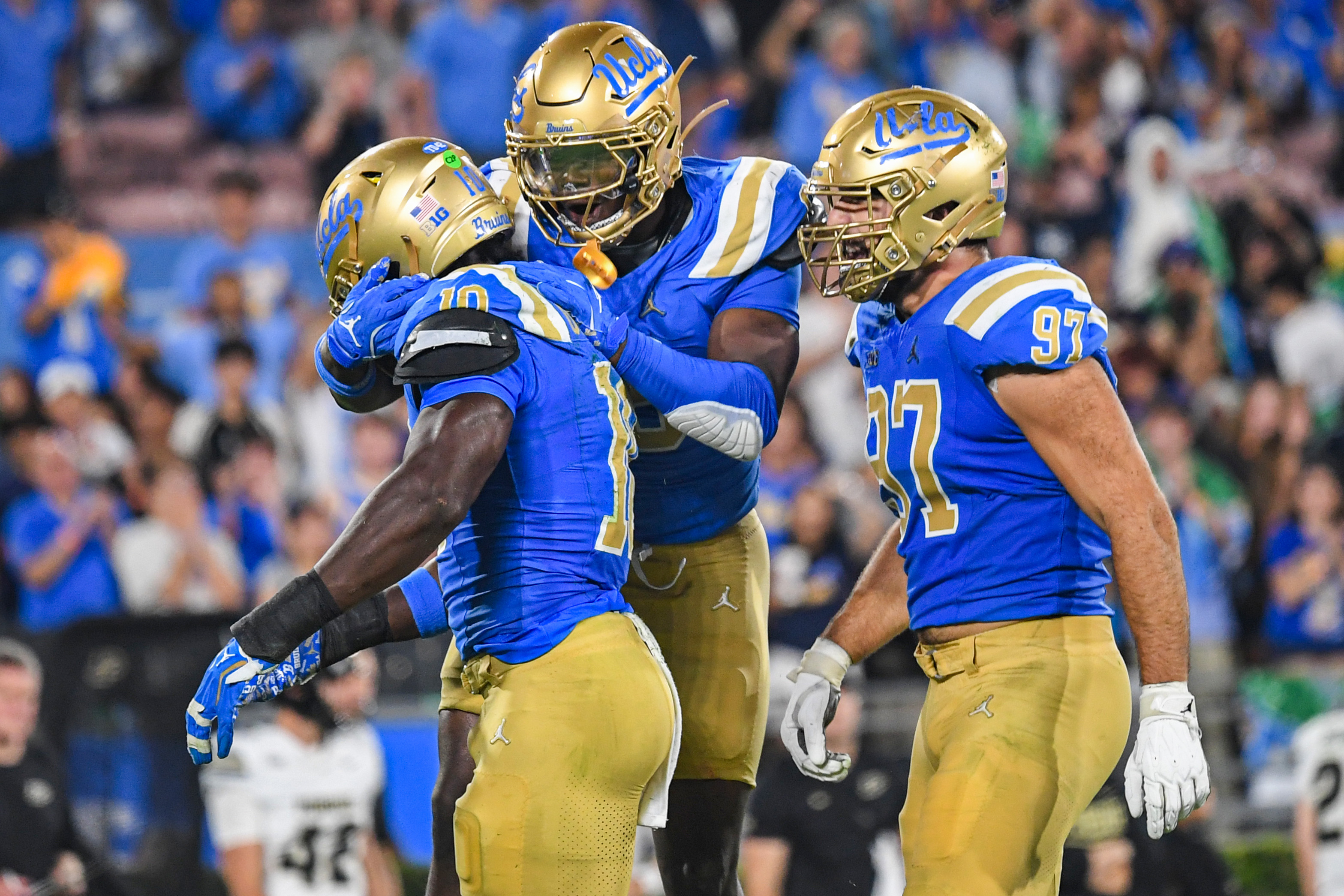 Senior linebacker Sammy Omosigho, fifth-year linebacker Jalen Woods and fifth-year defensive lineman Aiden Gobaira (left to right) celebrate Omosigho's first sack of Browne on Saturday. (Kai Dizon/Assistant Photo editor)