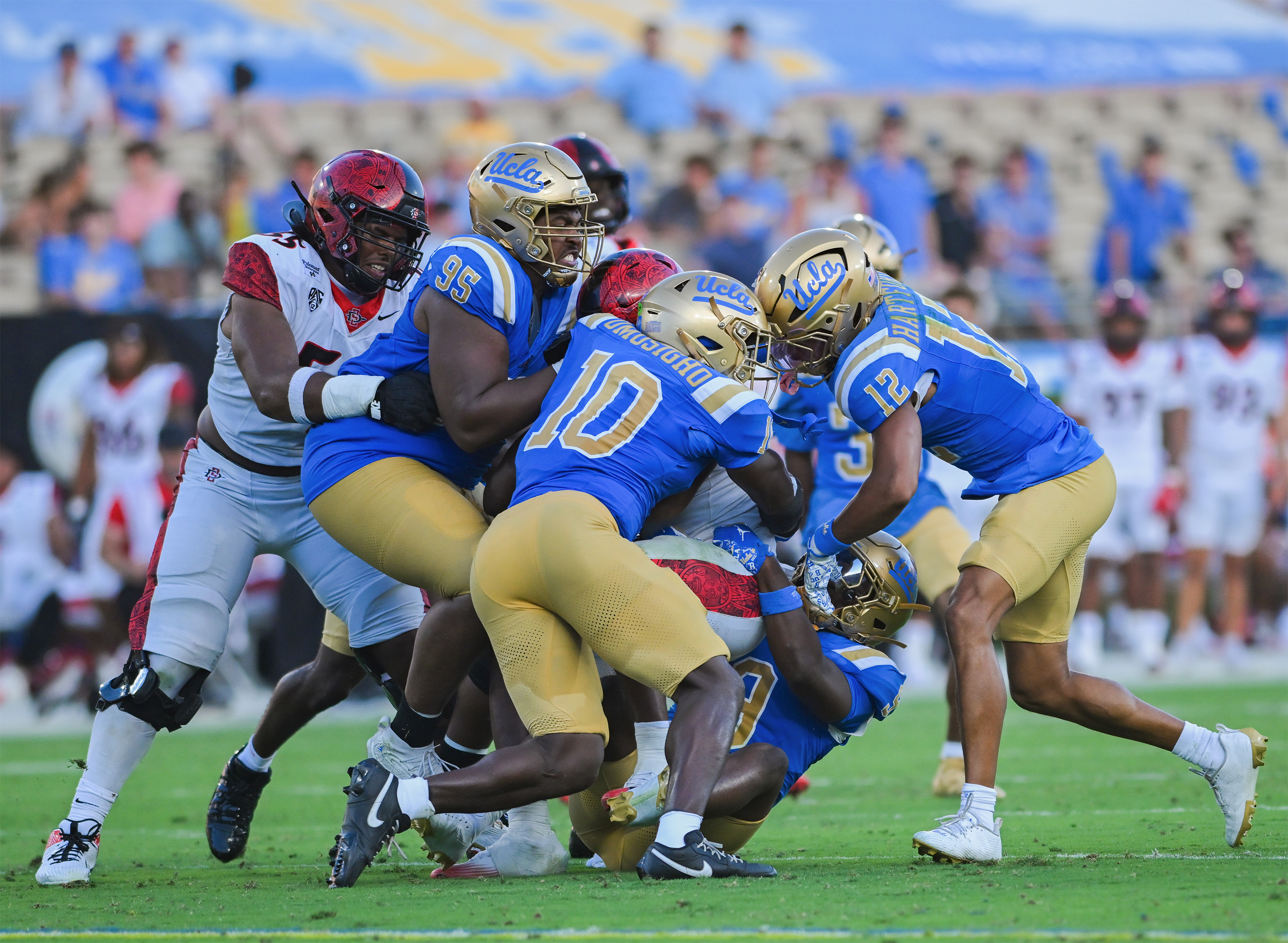 Four Bruin defenders take down an opposing San Diego State player. (Presley Liu/Daily Bruin senior staff)