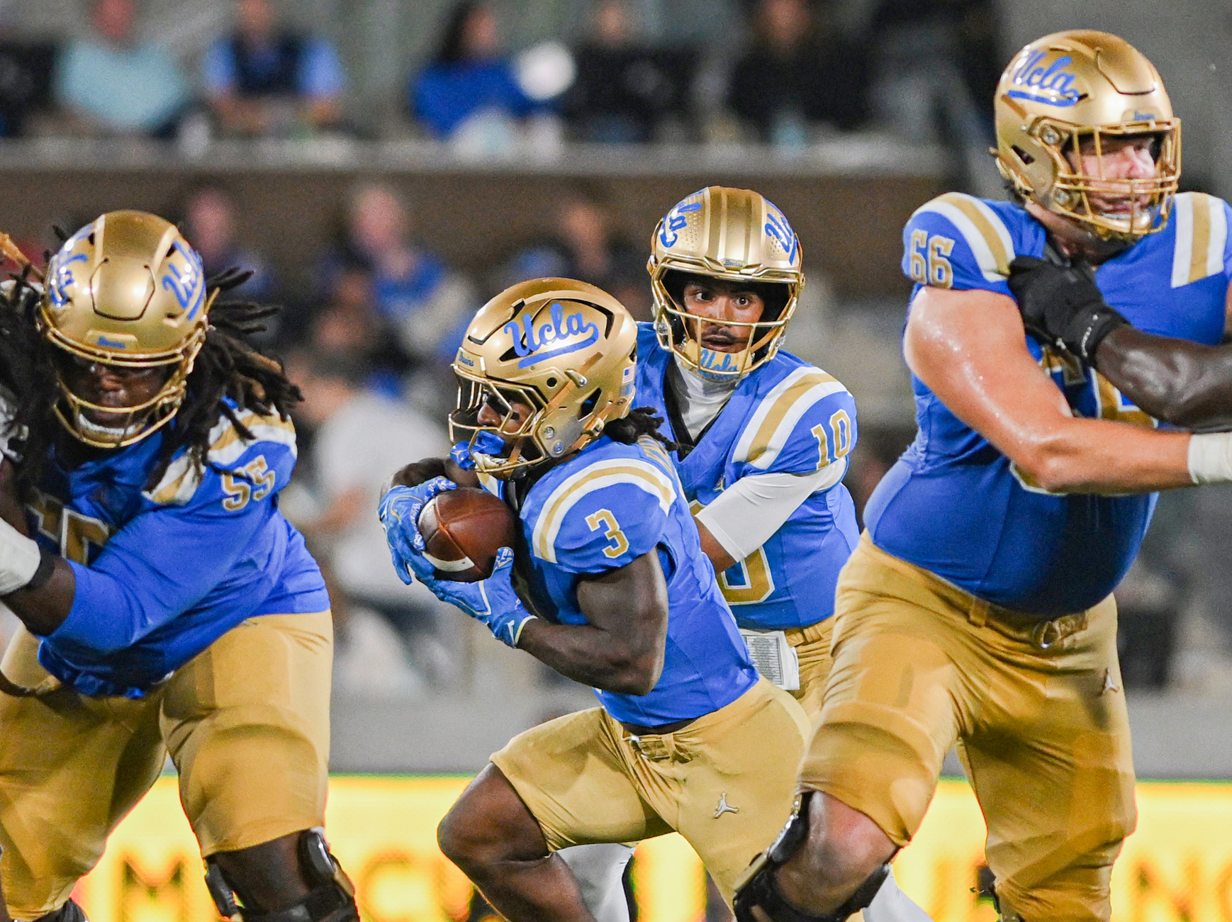 Sophomore quarterback Madden Iamaleava (second from right) hands the ball off to fifth-year running back Wayne Knight (second from left) against Purdue. (Kai Dizon/Assistant Photo editor)