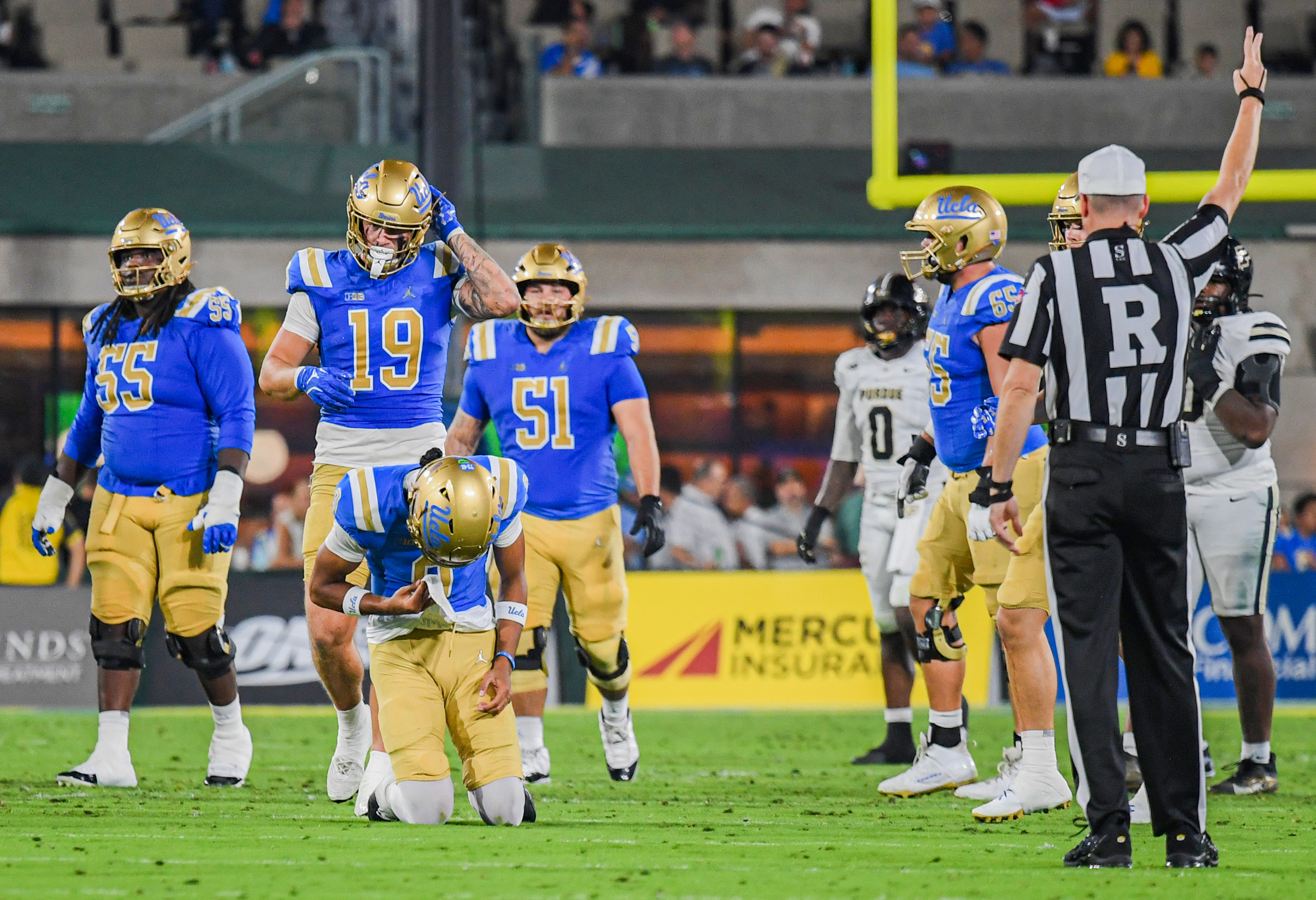 Iamaleava hangs his head with his knees on the ground after a play against Purdue on Saturday at the Rose Bowl. (Kai Dizon/Assistant Photo editor)
