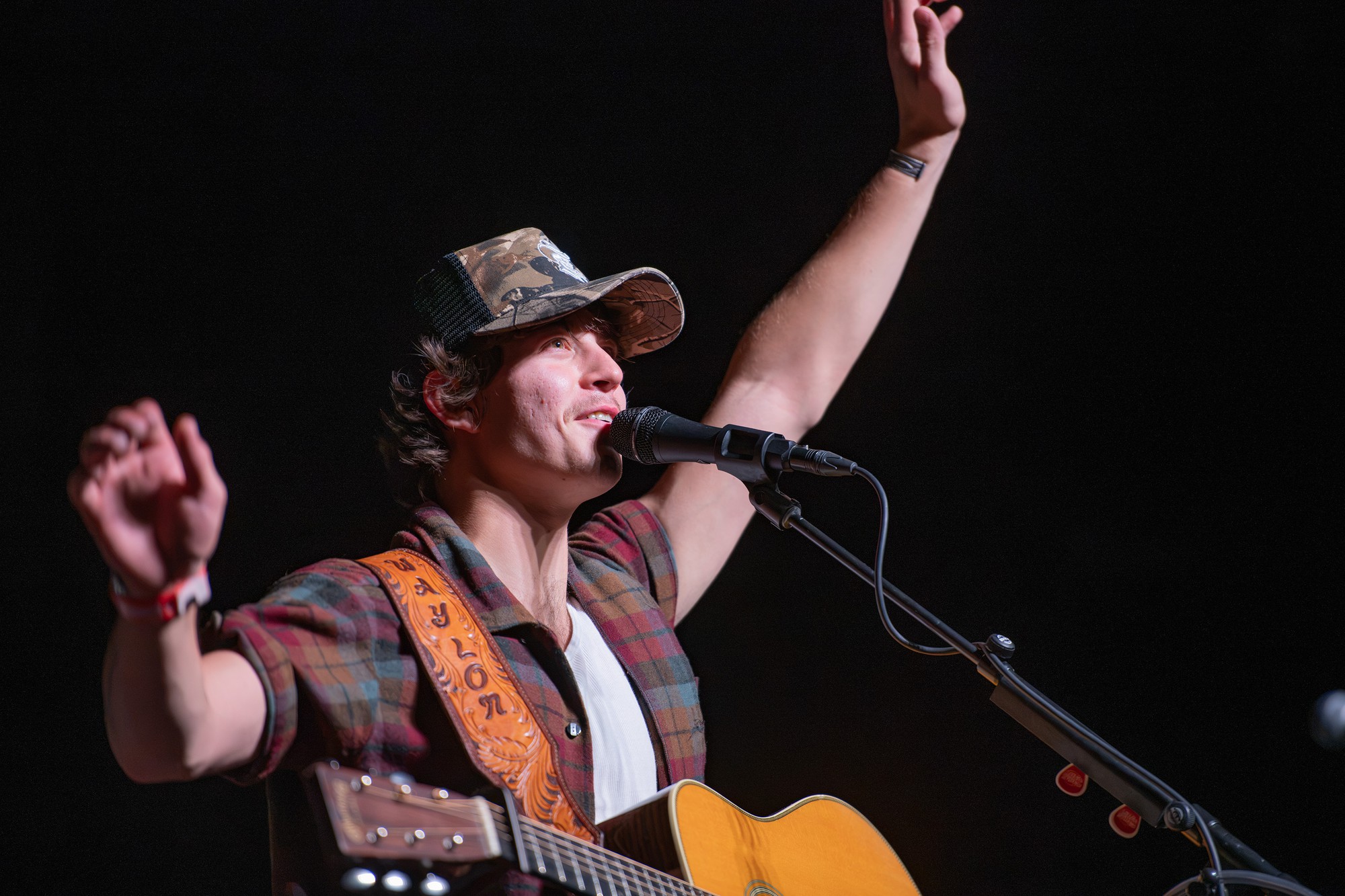 The artist stands in a camouflage hat, looking out at the crowd. Wyatt largely highlighted many songs from his debut studio album “Dustpiles.”(Selin Filiz/Daily Bruin senior staff)