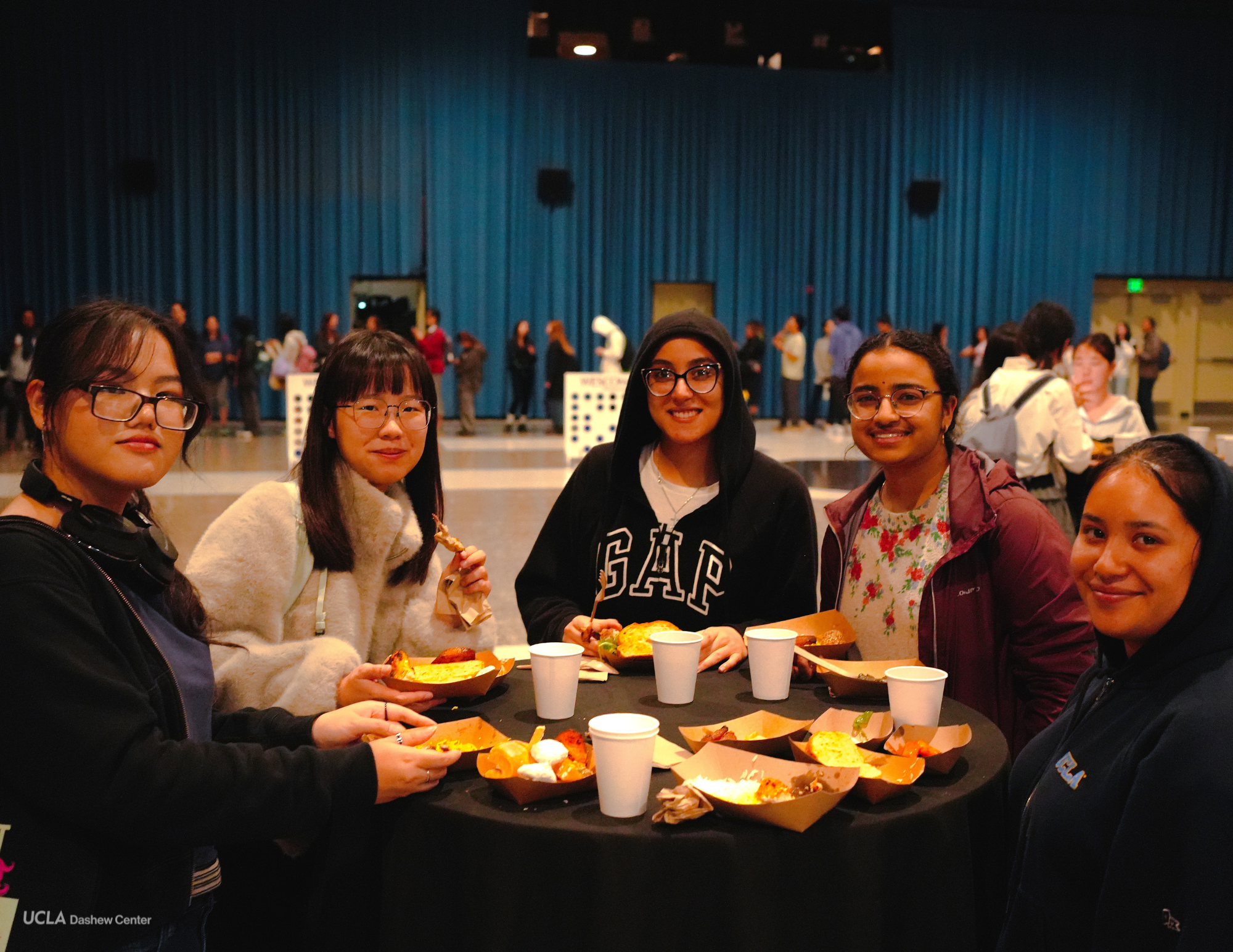 Students sit around a table enjoying different dishes at the International Food Festival. The event, which was a collaboration between the UCLA Dashew Center for International Students and Scholars, Wescom Financial and ASUCLA, was held at the Ackerman Union Grand Ballroom on Wednesday from 5:30 to 8:30 p.m. (Courtesy of Andrea Giraldo Morales)