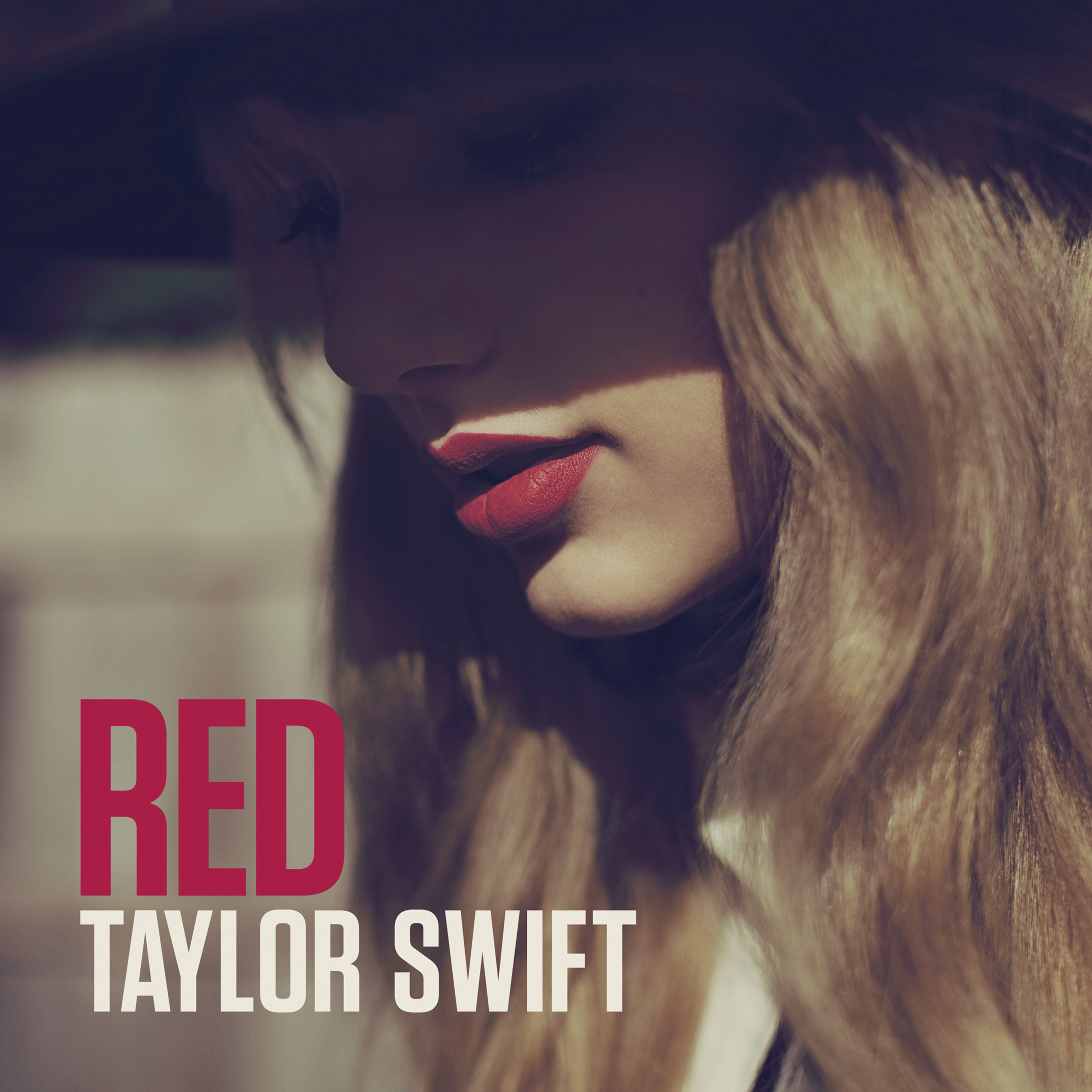 Swift looks downward in a wide-brimmed hat and wears red lipstick on the cover of “Red,” released in 2012. (Courtesy of 2012 Taylor Swift)