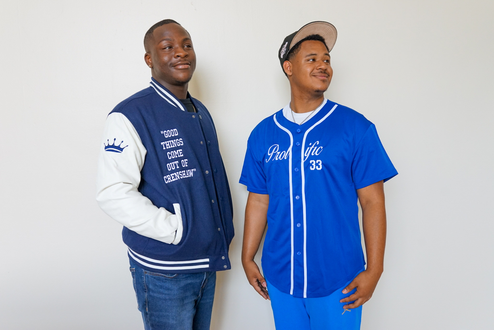 Ralph Adedeji and Williams pose wearing a Prolific Aftermath varsity jacket and jersey. Williams was born and raised in Crenshaw and said he hopes to counter negative media portrayals of the neighborhood by highlighting its beauty. (Courtesy of Derrick Williams)