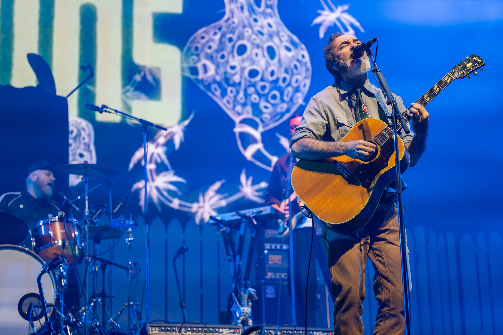 Members of The Shins, the second opening act of the night, are pictured on stage in blue lighting. The band breezed through its folk-rock songs, setting the tone before the final act. (Selin Filiz/Daily Bruin senior staff)