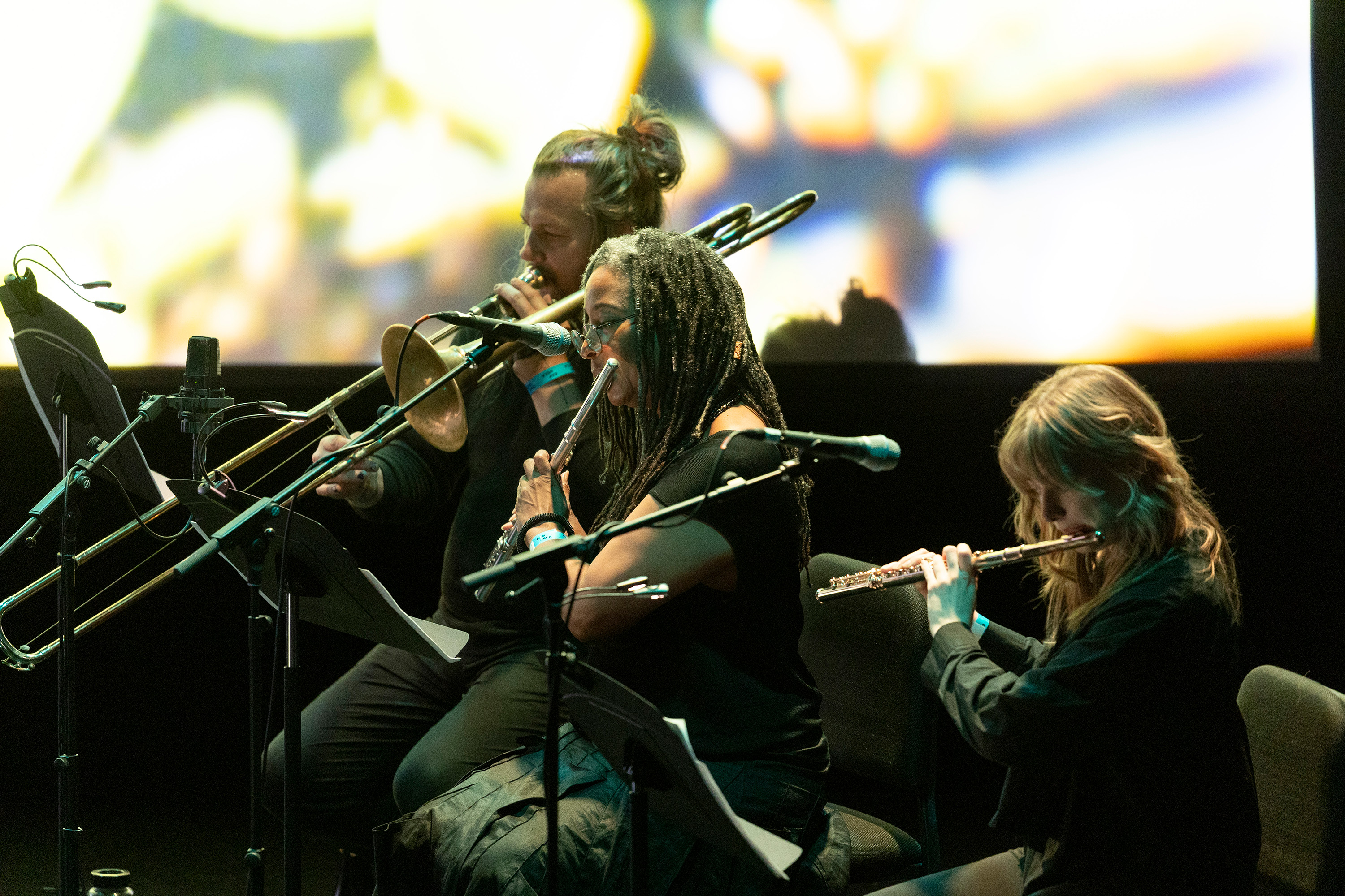 Various musicians sit aligned onstage donning all-black clothing. Jackson is a Los Angeles native known for her electroacoustic, chamber and orchestral music, which she has performed internationally at notable venues, such as Carnegie Hall. (Courtesy of Bailey Holiver)