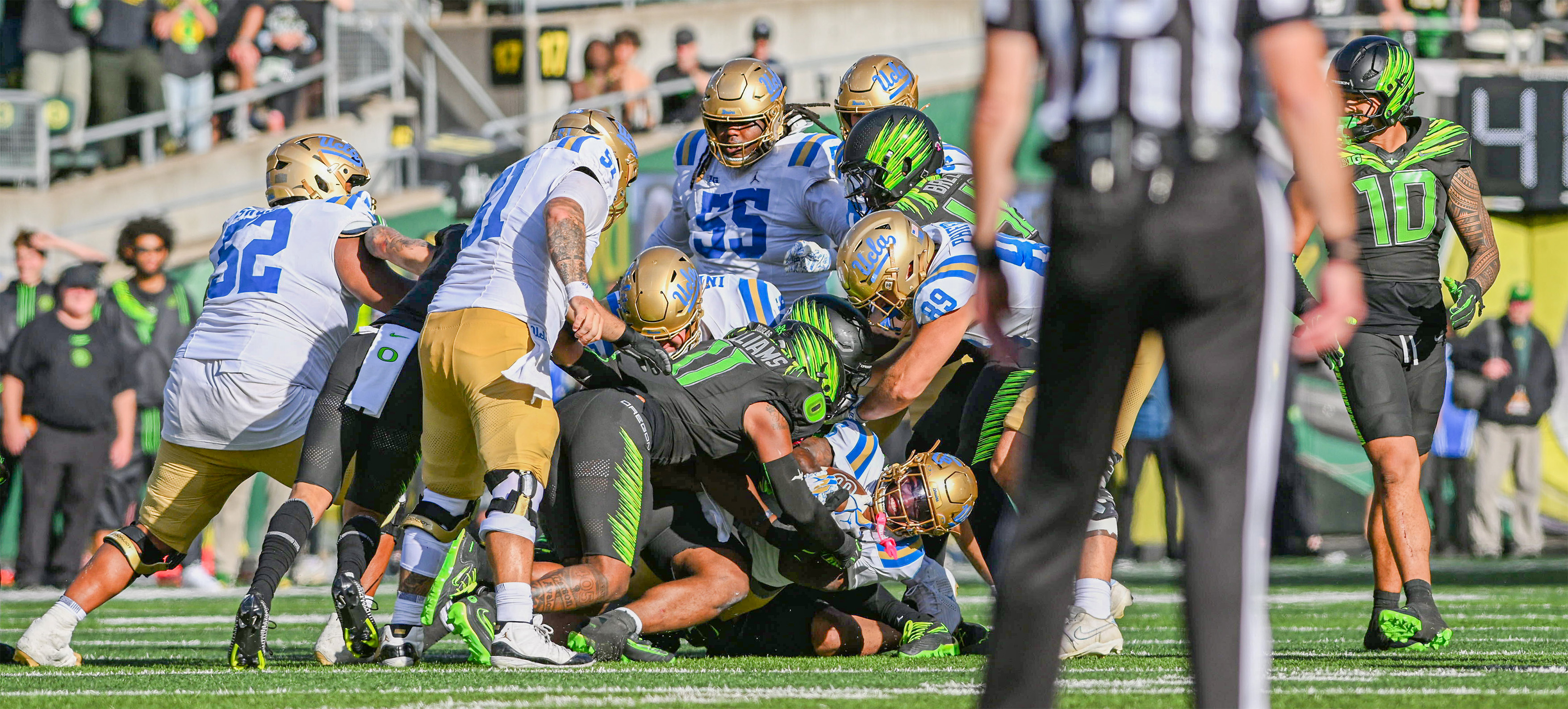 Fifth-year running back Anthony Woods holds onto the ball at the bottom of a dogpile. (Bettina Wu/Daily Bruin senior staff)