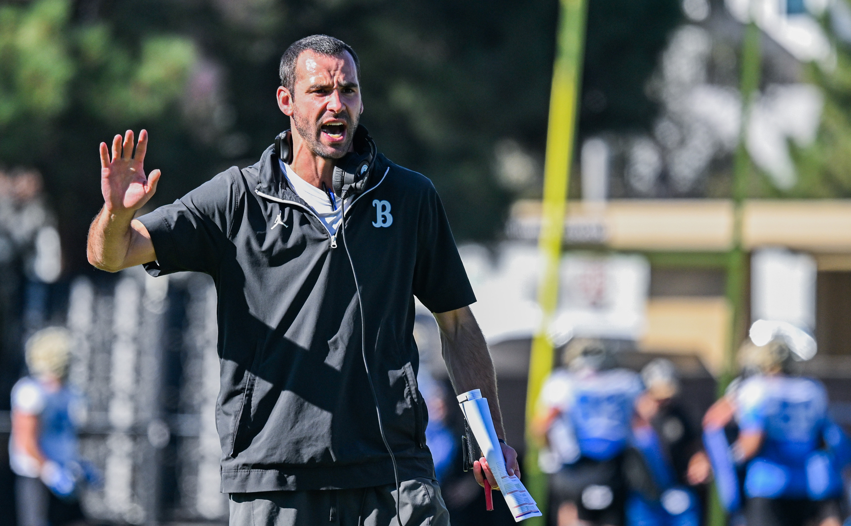 Offensive coordinator Dean Kennedy holds his right hand up during a UCLA practice. Kennedy joined Chesney on his move from JMU to Westwood. (Kai Dizon/Assistant Photo editor)