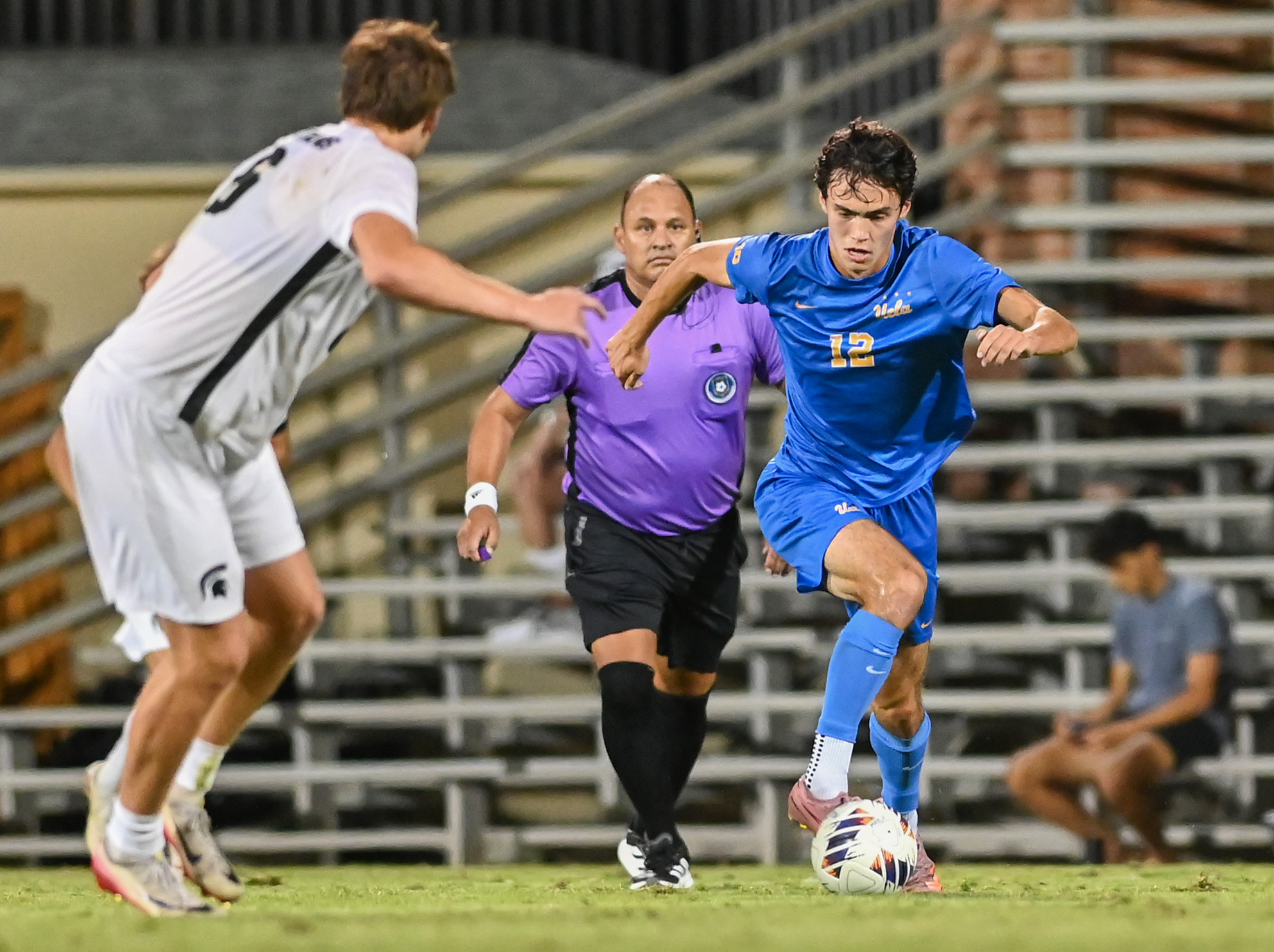 Junior midfielder Zach Neuls dribbles toward a Michigan State defender. Neuls is tied for second on the squad in goals, having tallied three through the season. (Elle Smith/Daily Bruin staff)